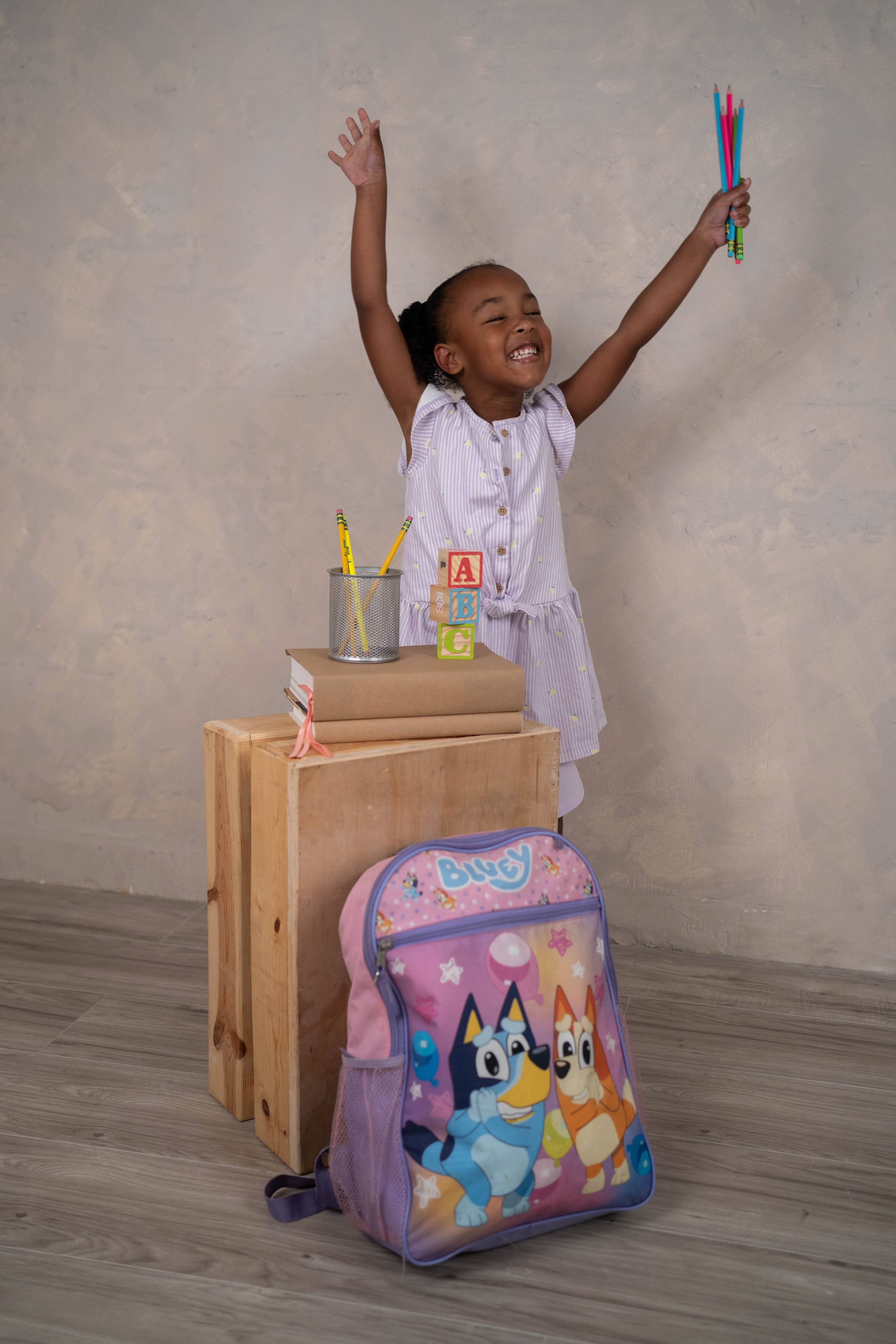 Child smiling in a back-to-school mini session setup.