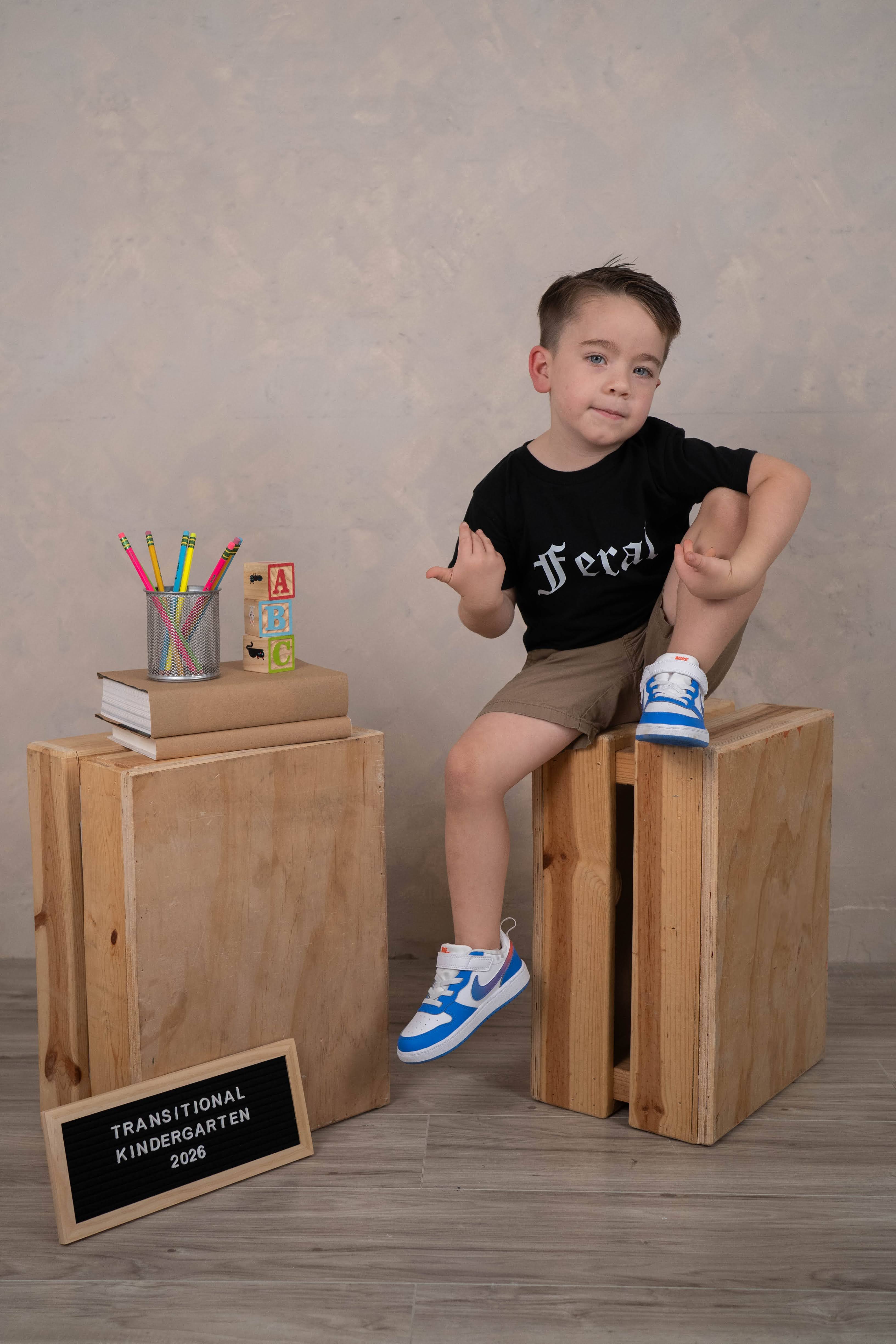 Child posing for a school-year portrait in the Back To School Minis setup.