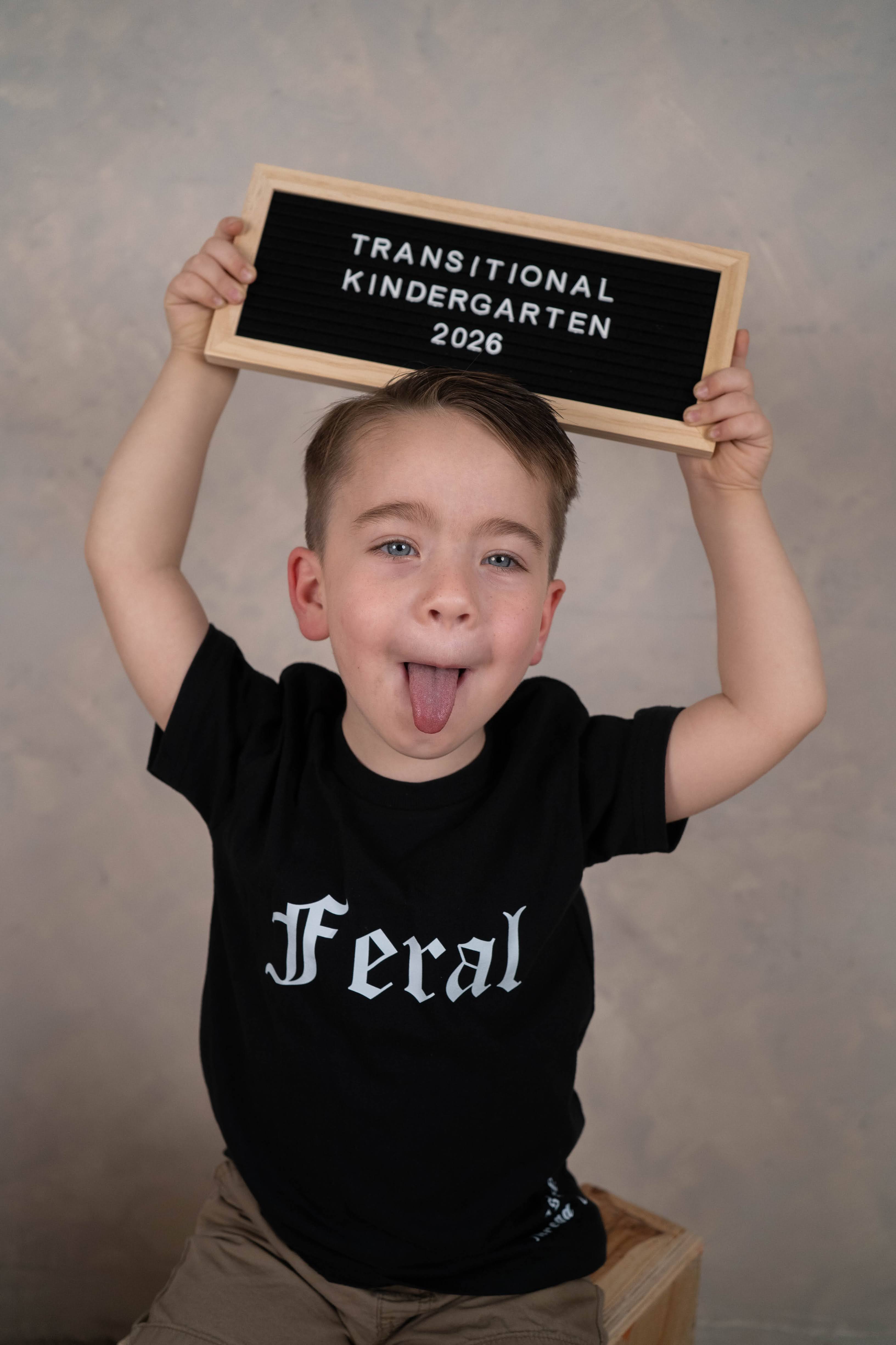 Child posing in a back-to-school mini session setup with school props.