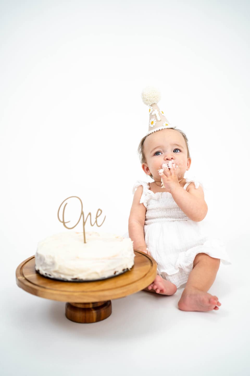 Child sitting for a first birthday portrait during a Vacaville cake smash session.
